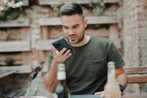 Making-Your-VoIP-Network-Bulletproof-Featured-Image.jpg - Onpoint Systems man in gray crew neck long sleeve shirt holding black smartphone